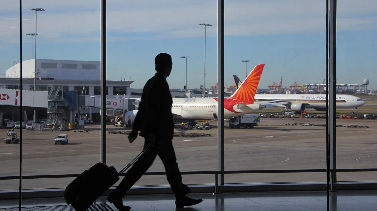 Dirigeant expatrié traversant un terminal d'aéroport avec sa valise